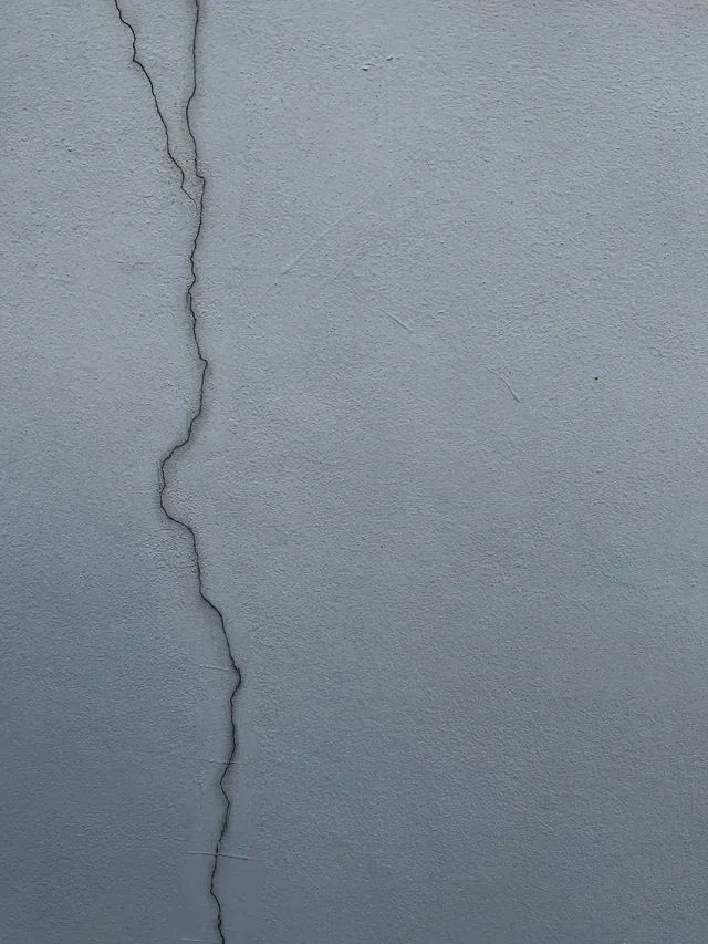 Hairline crack running across a concrete wall